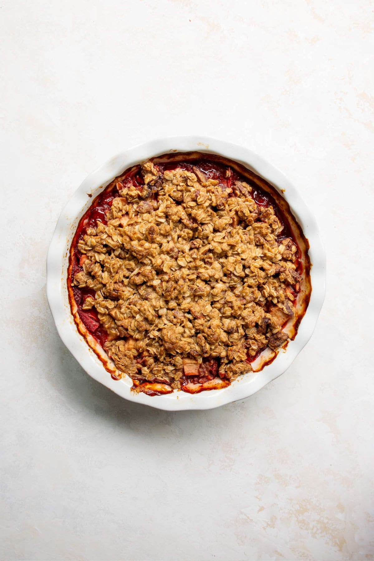 Baked strawberry apple crumble in a pie dish.
