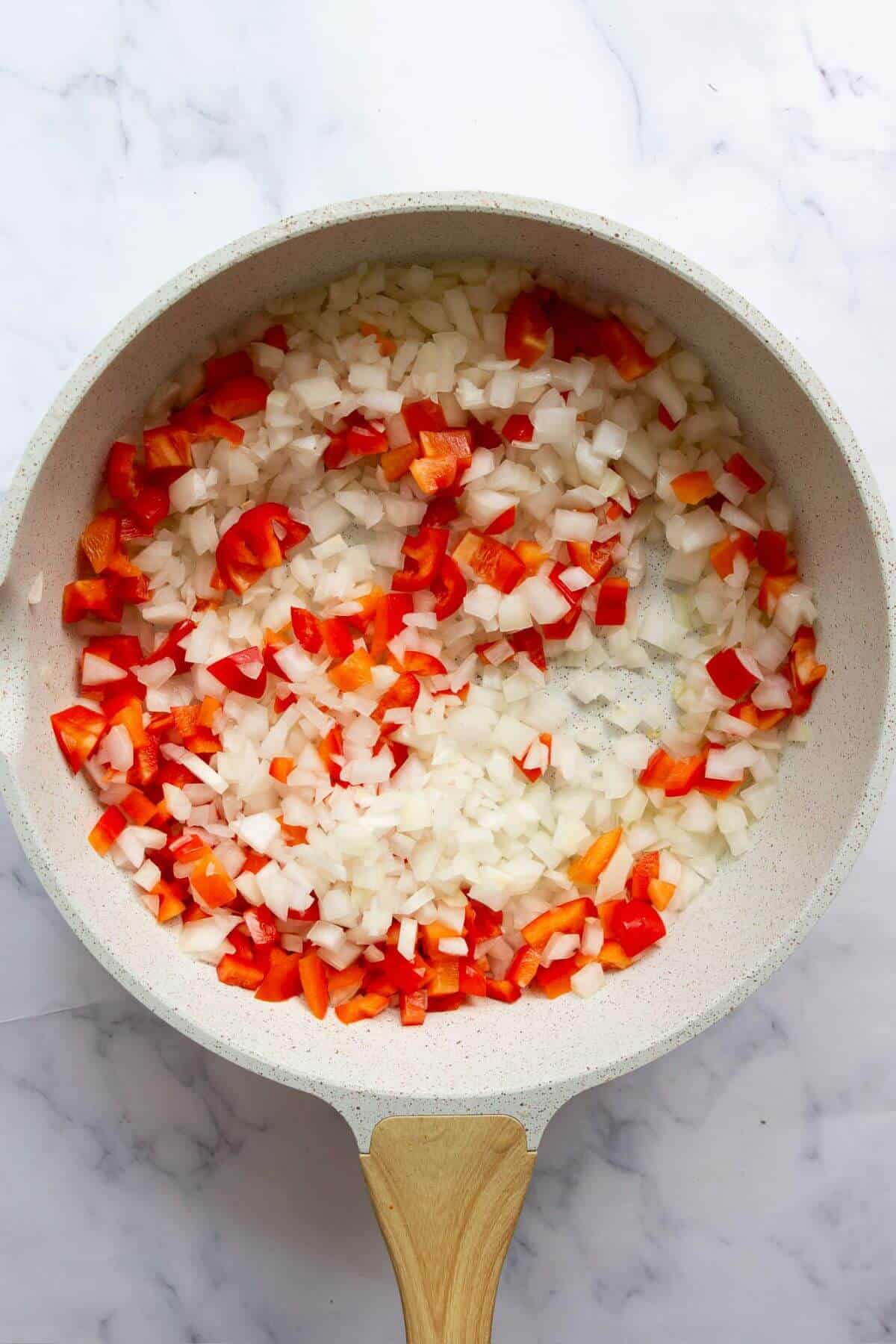 Cooking onion and bell pepper for turkey taco stuffed sweet potatoes filling.