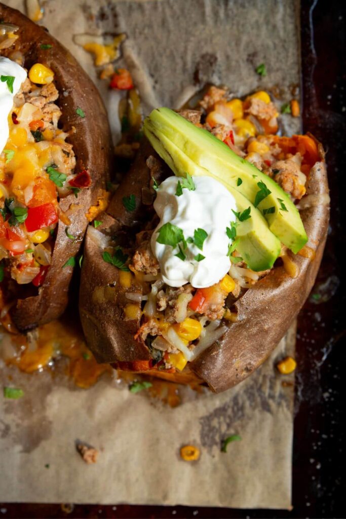 stuffed sweet potatoes with bell pepper, corn, avocado and cheese