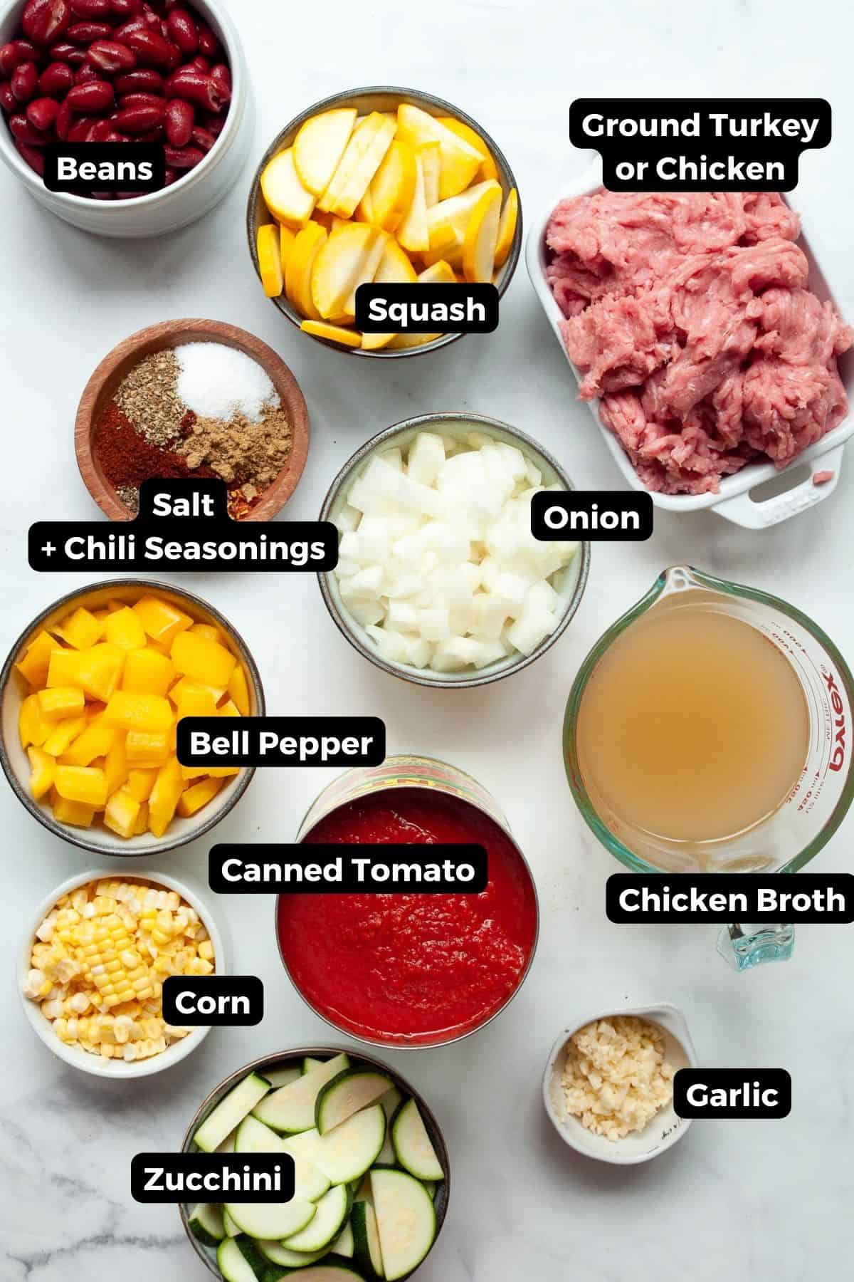 Ingredients for healthy turkey chili including ground turkey, zucchini, bone broth, yellow squash, bell pepper, kidney beans, corn, and chili seasonings.