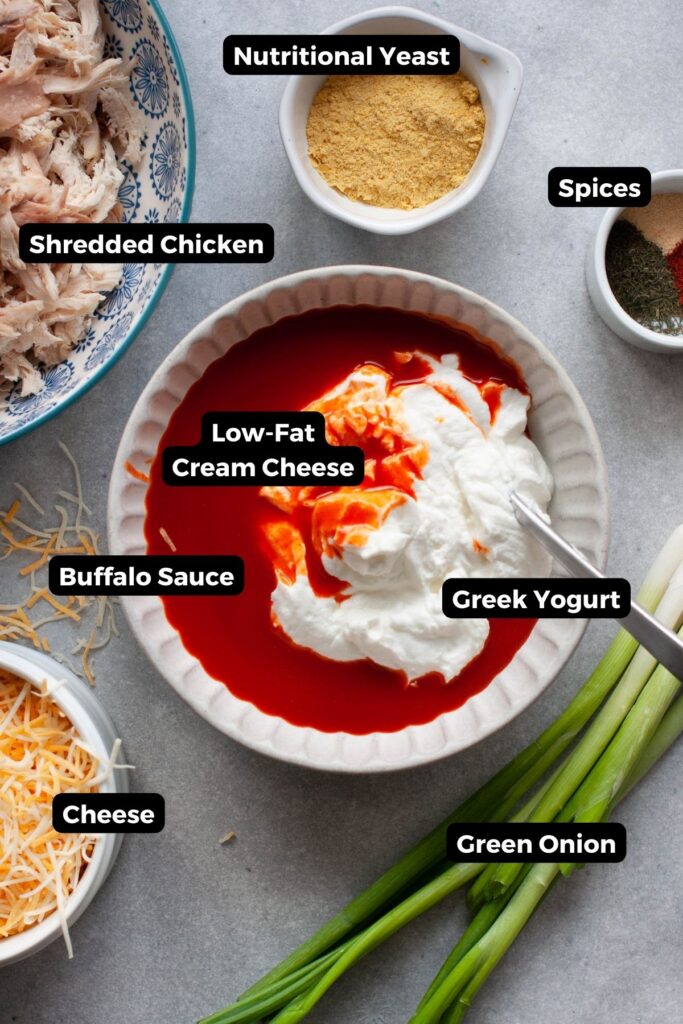 all ingredient in healthy buffalo chicken dip in bowls with labels