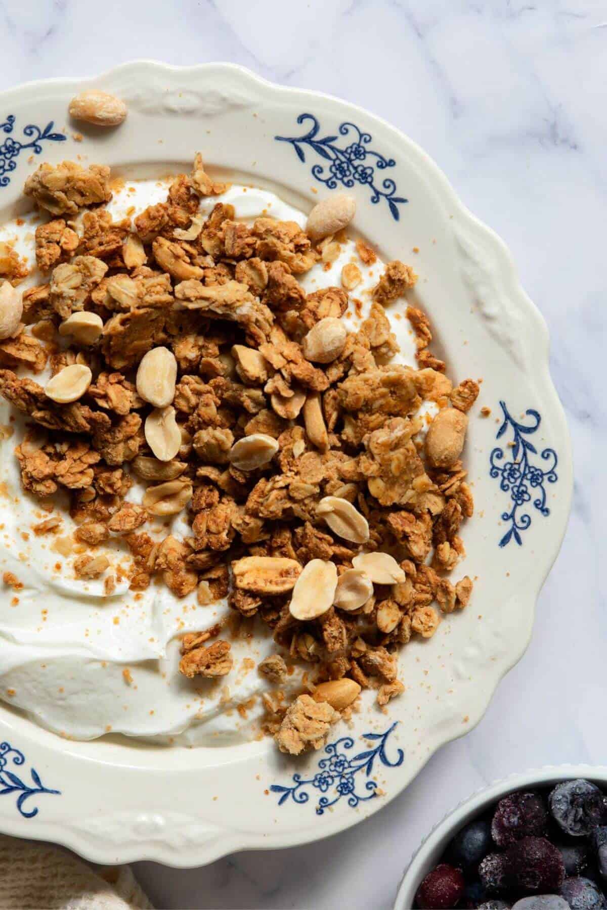 Chunky peanut butter granola served on top of vanilla Greek yogurt with sliced banana, blueberries, and an extra drizzle of peanut butter.