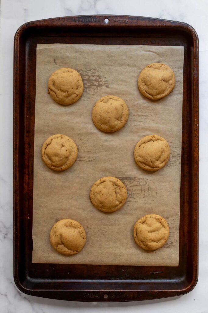 baked healthy sugar cookies on a parchment-lined baking sheet