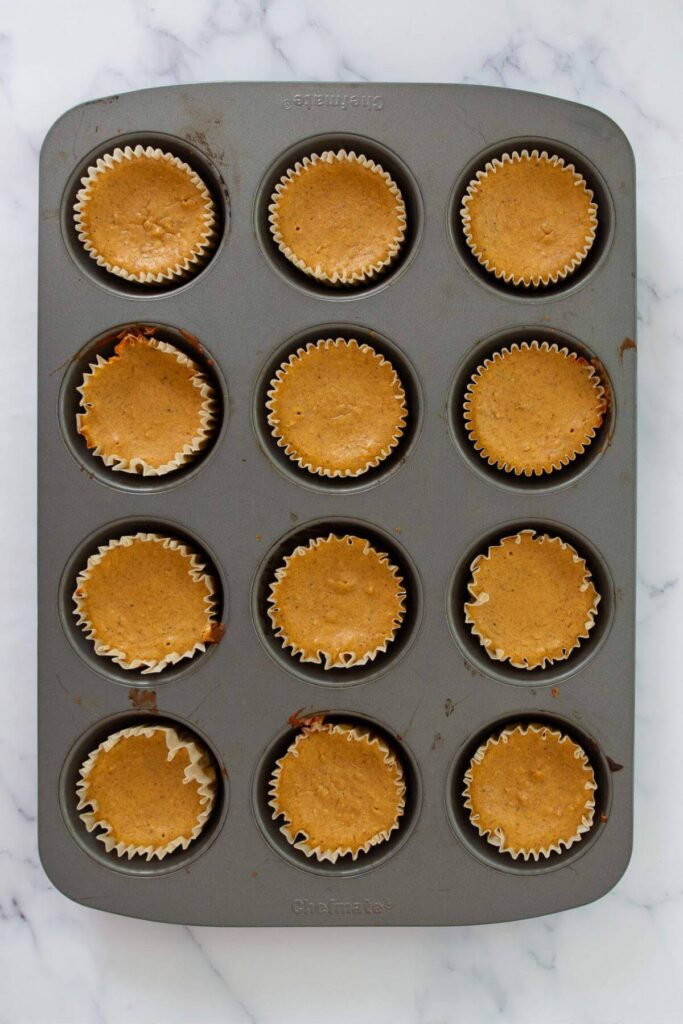 baked mini pumpkin protein cheesecakes in a muffin tin
