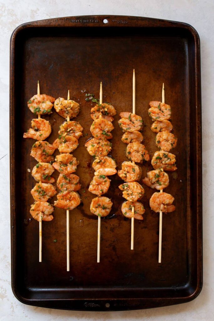 cooked shrimp skewers on a baking dish