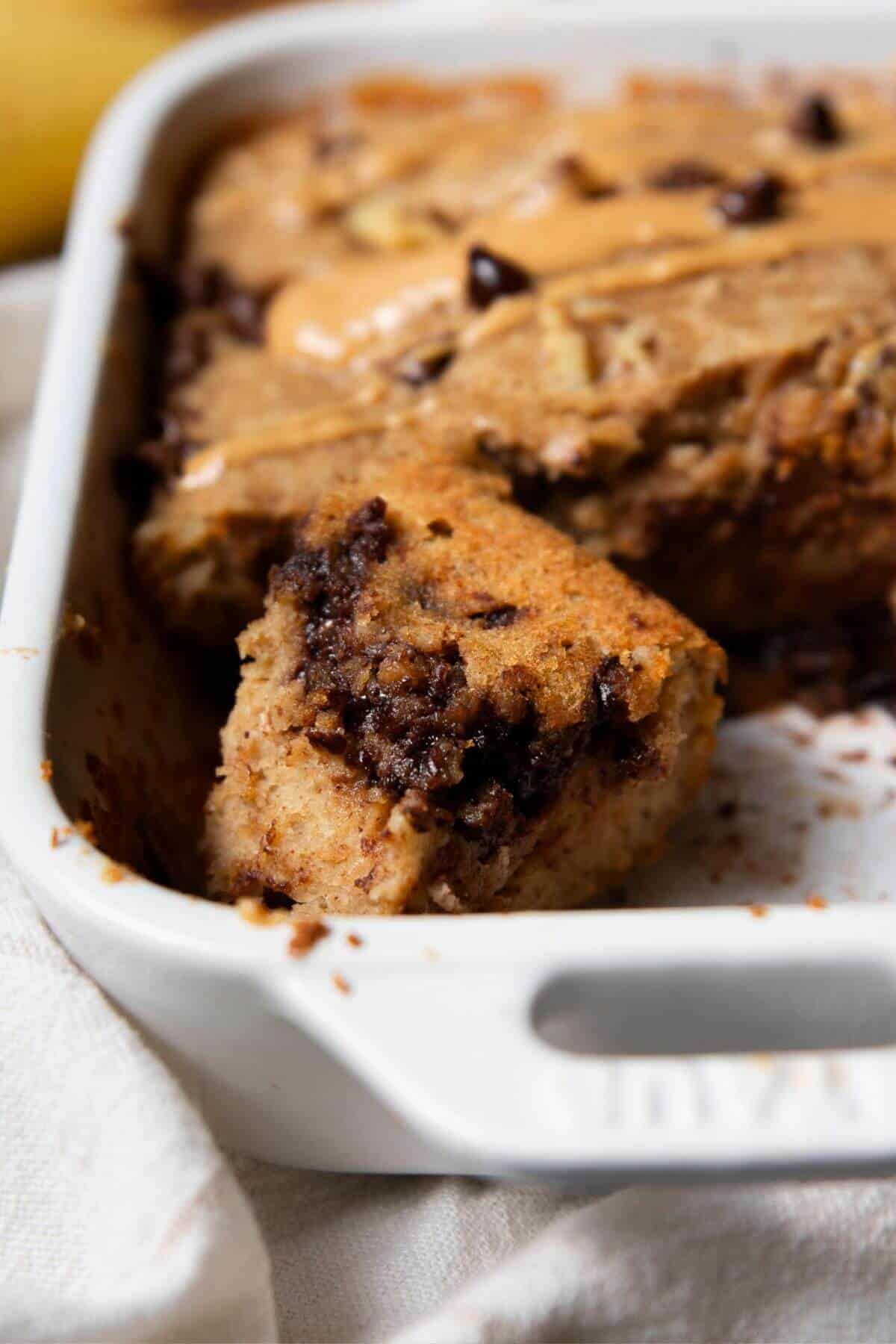 A piece of healthy single serve banana bread showing the soft, fluffy chocolate chip studded inside.