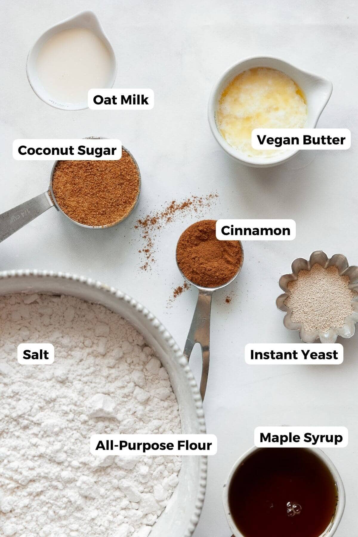 Vegan monkey bread ingredients labeled: oat milk, vegan butter, coconut sugar, cinnamon, instant yeast, salt, all-purpose flour, maple syrup.
