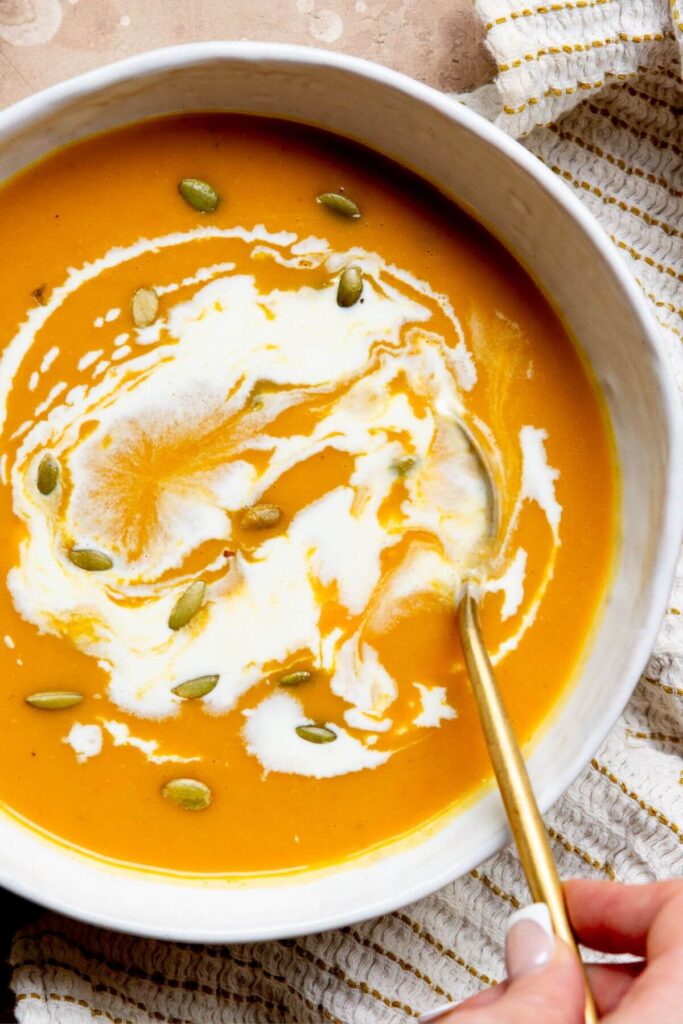 easy carrot and butternut squash soup in a bowl with coconut milk