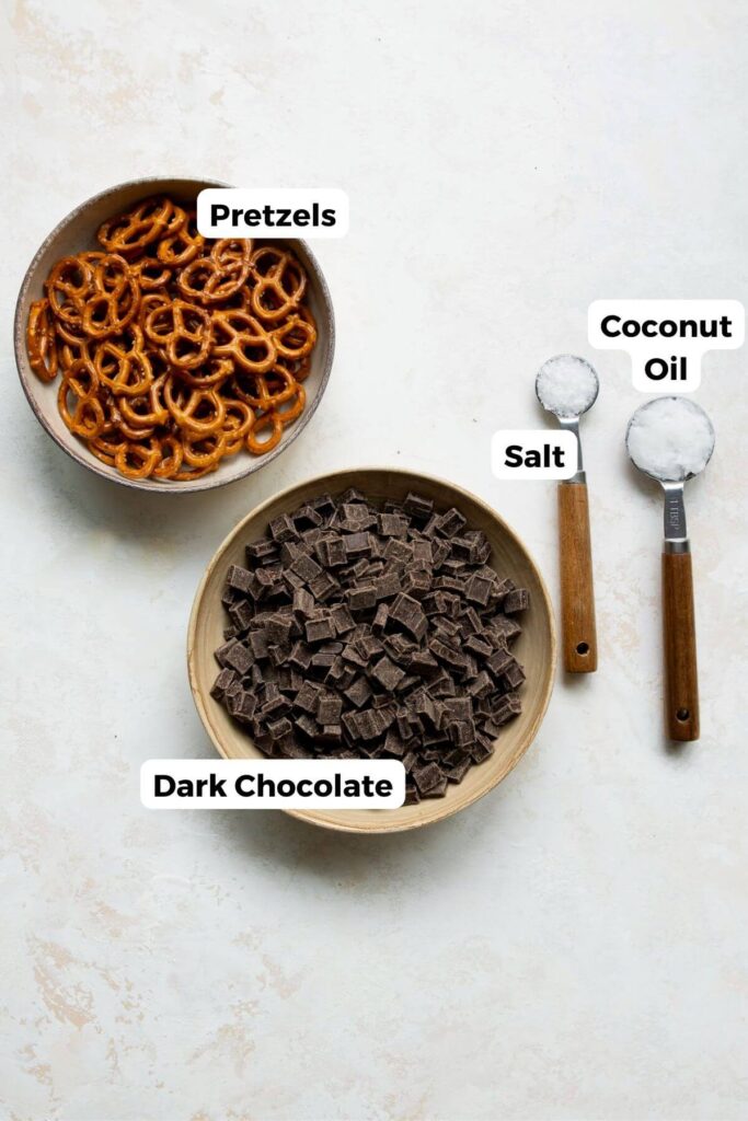 all four ingredients in chocolate pretzel bark in small bowls with labels