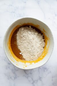 adding oat flour, baking soda, and baking powder to the wet ingredients