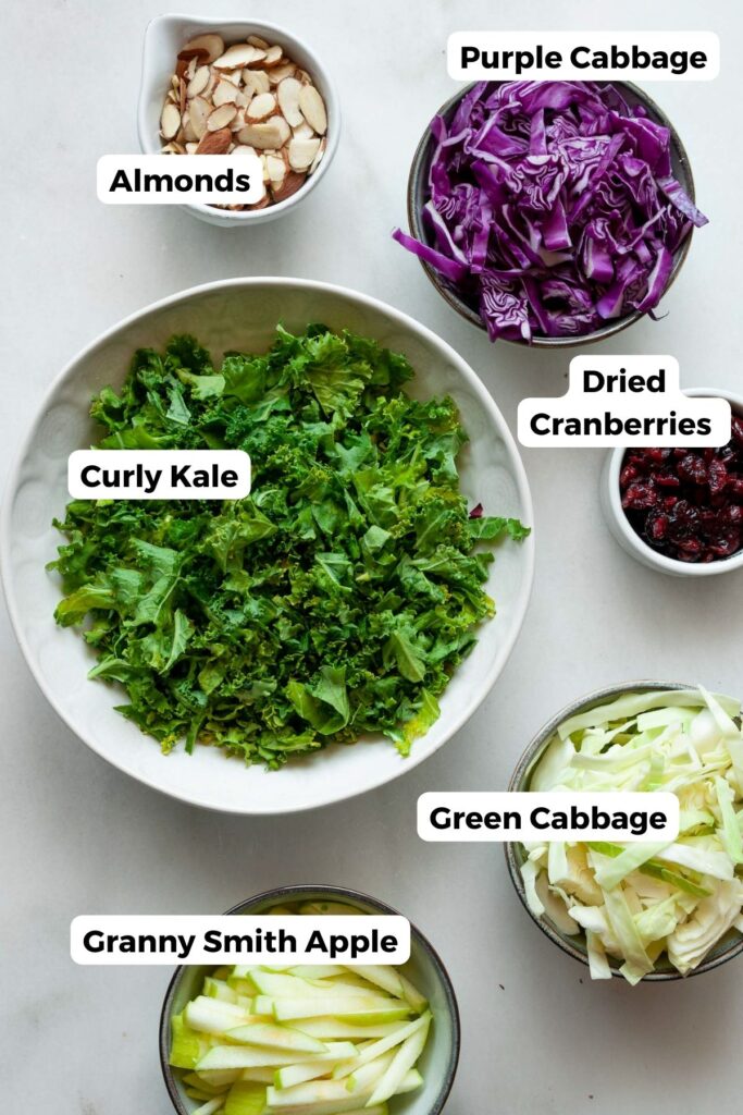 all ingredients in kale crunch salad in small bowls with labels