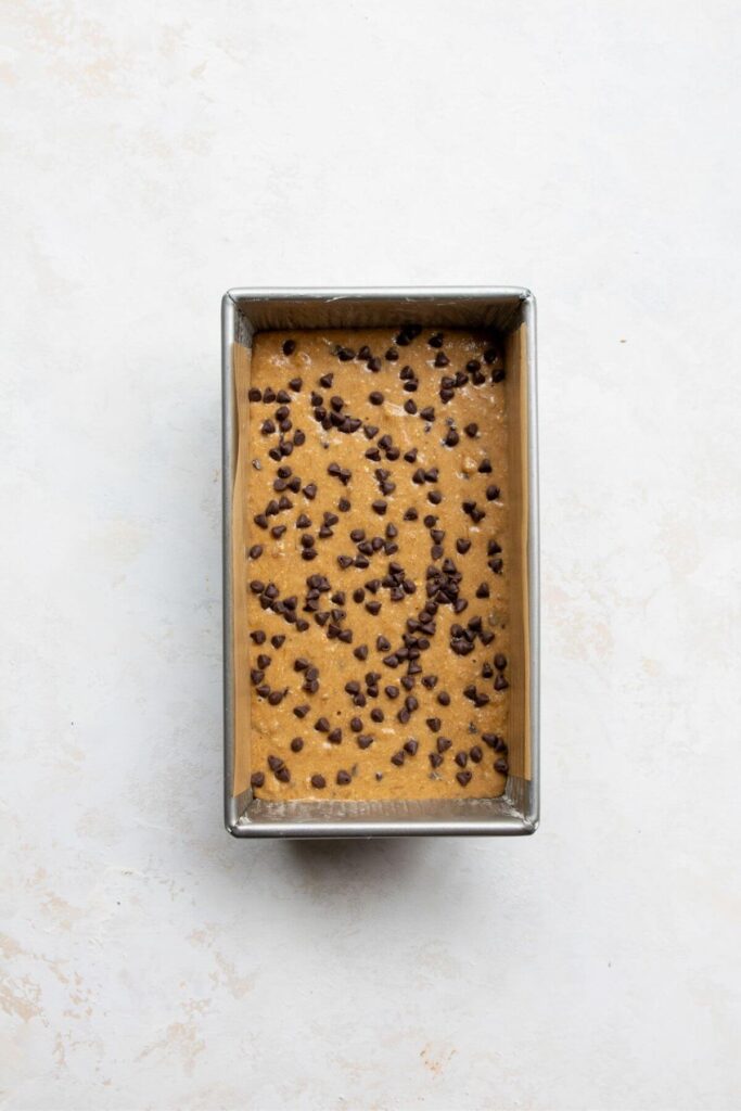 oat flour banana bread batter in a baking tin with chocolate chips on top