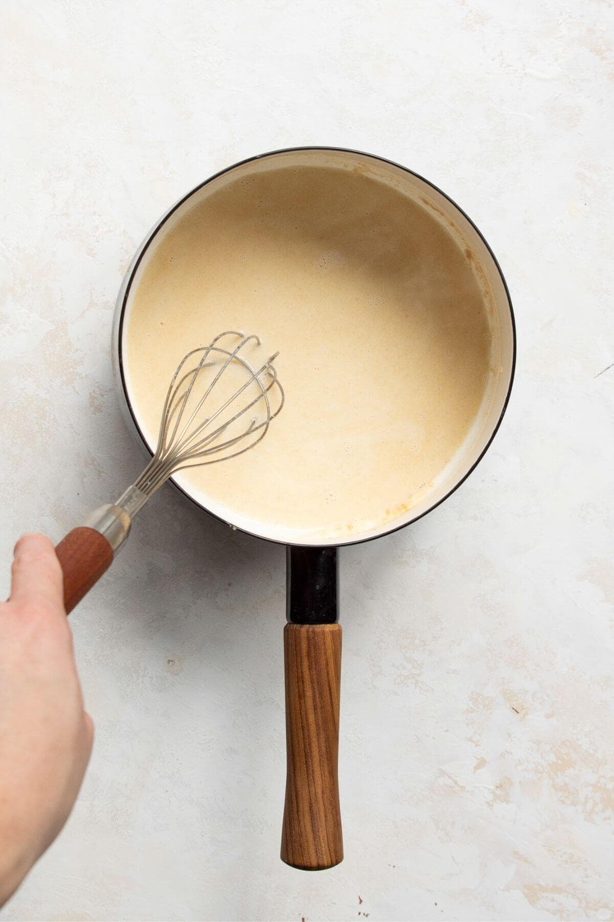 adding milk and broth to the pot