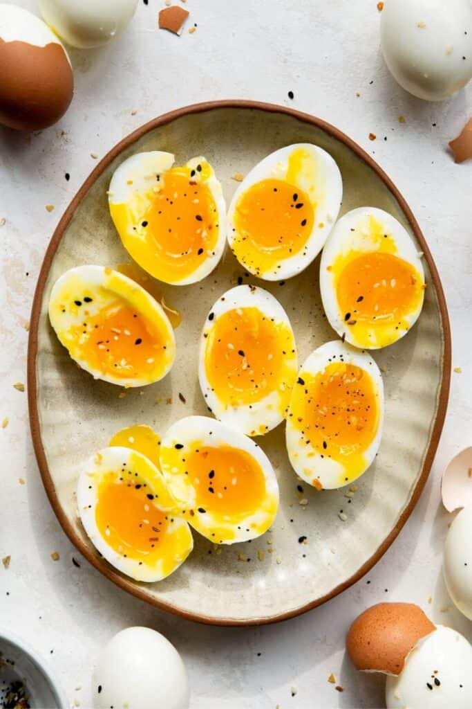 air fryer soft-boiled eggs cut in half to show the jammy, yolky middles