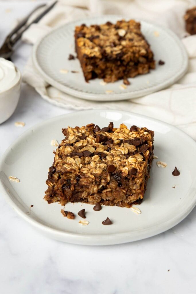 super moist vegan baked oatmeal slice on a plate with chocolate chips