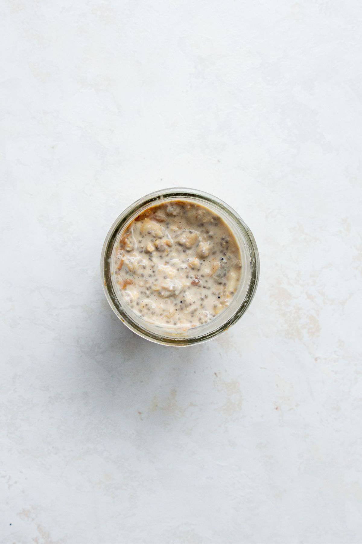 Overhead view of creamy overnight oats in a jar after chilling.