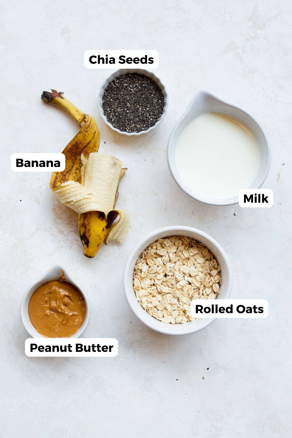 Ingredients for peanut butter banana overnight oats: rolled oats, banana, milk, peanut butter, and chia seeds.
