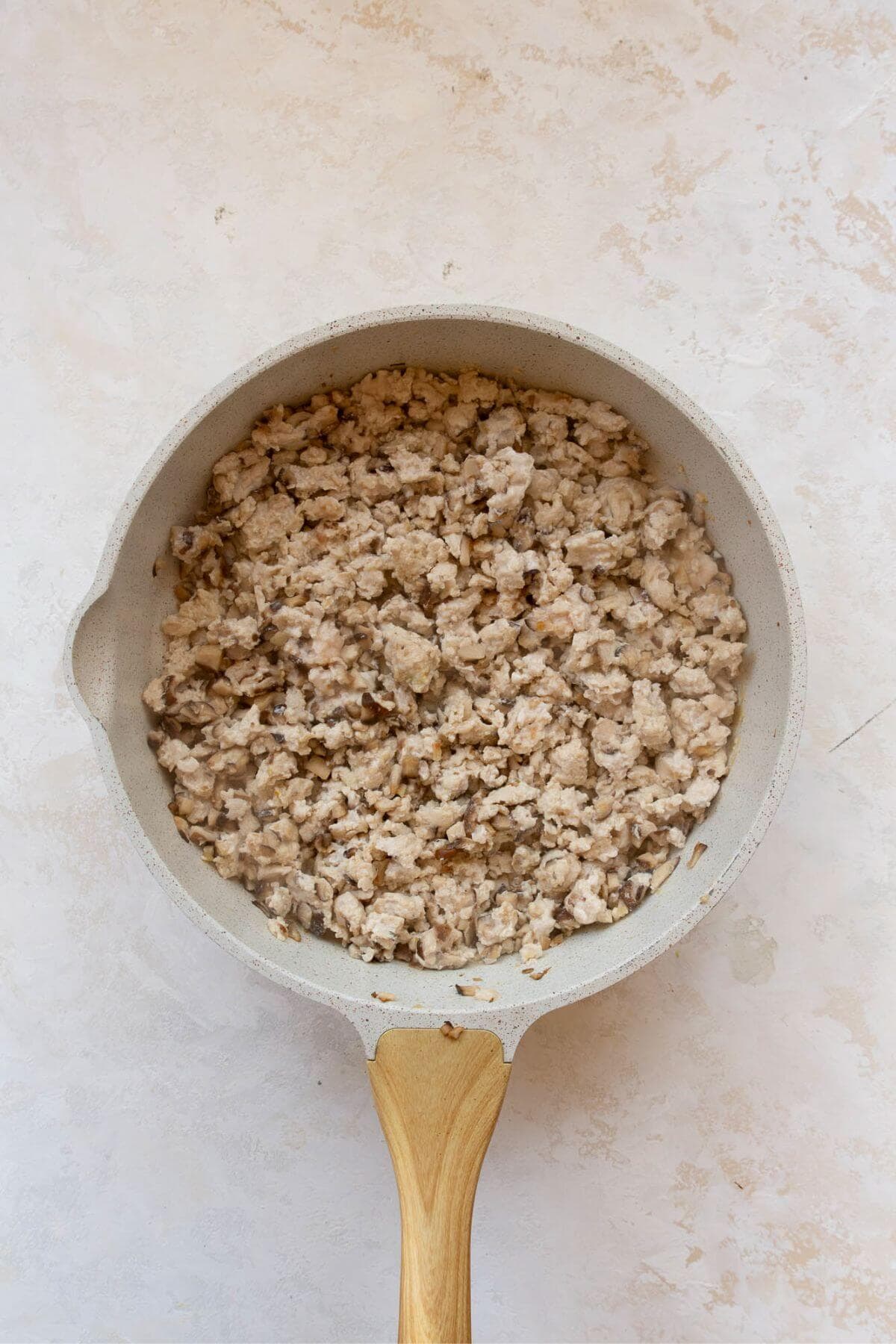 Ground chicken and mushrooms cooked together in a pan.