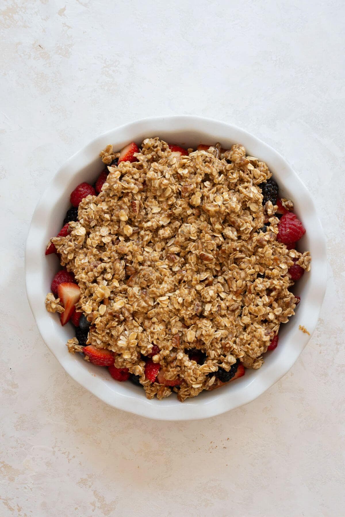unbaked berry crisp in a pie dish