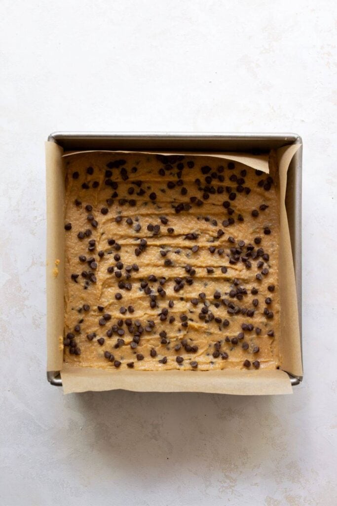 raw batter chocolate chip chickpea blondies in a baking dish