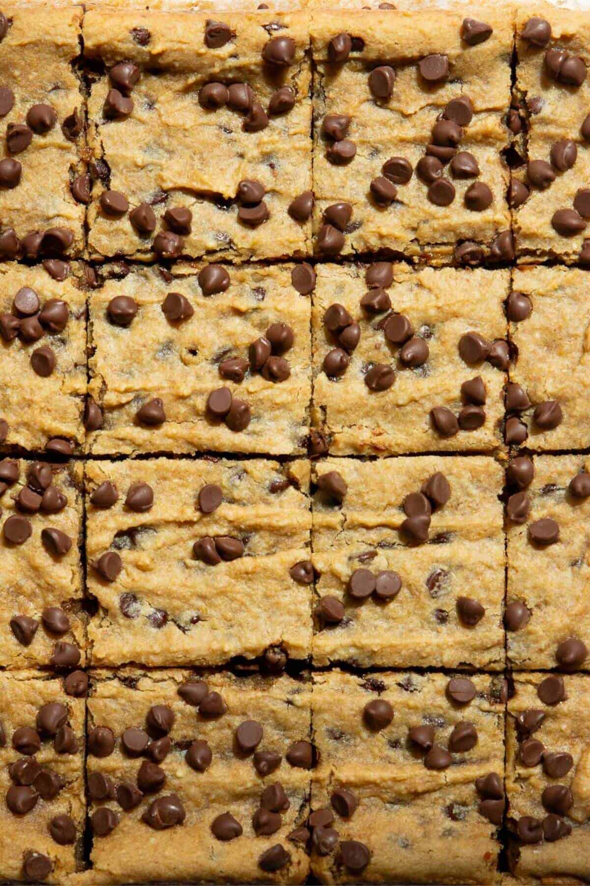 Healthy chickpea blondies cut into squares and topped with chocolate chips.