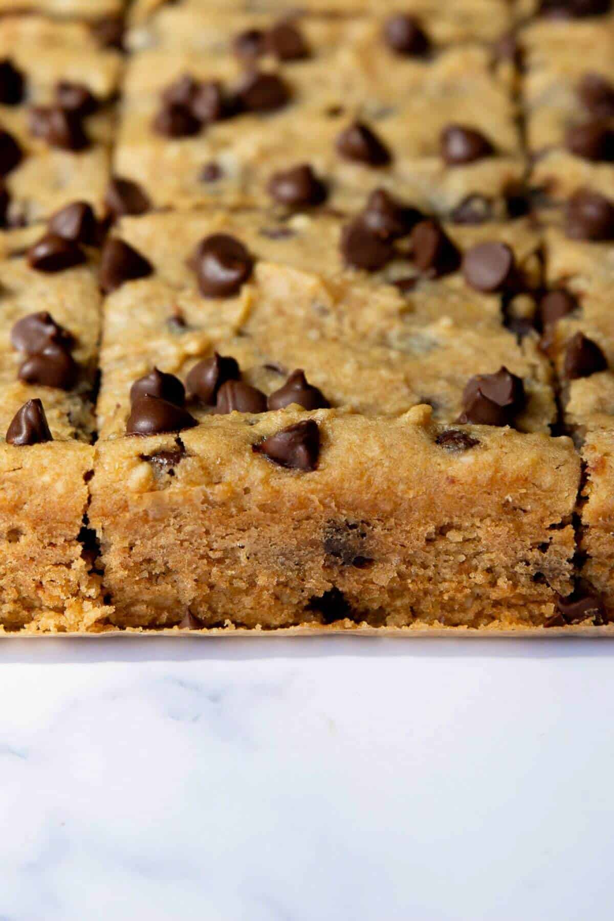 Side view of a thick, fudgy chickpea blondie showing the soft center.