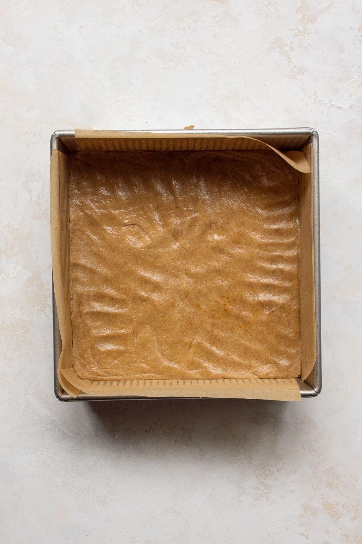 Pressing the blueberry bar crust into the baking pan.