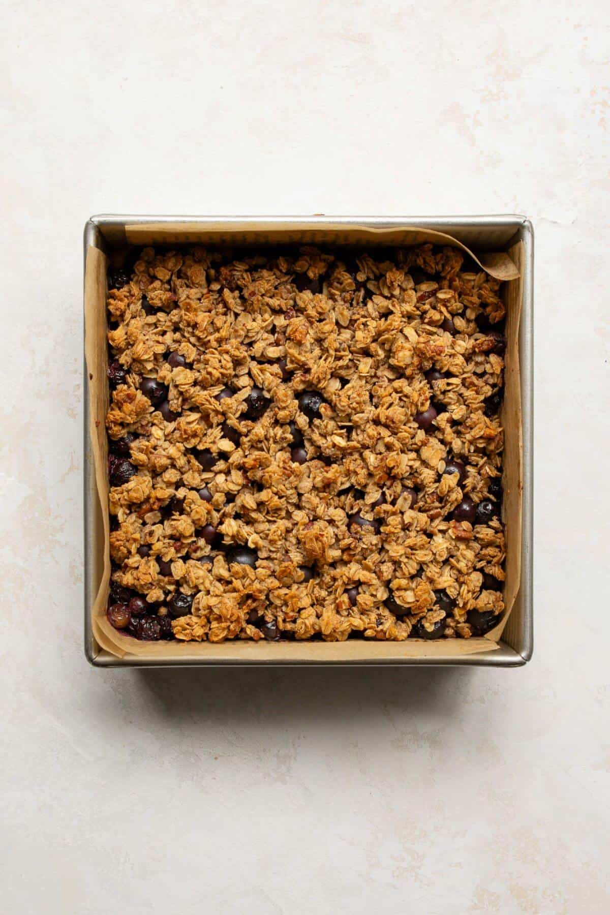Freshly baked blueberry crumble bars cooling in the pan before slicing.