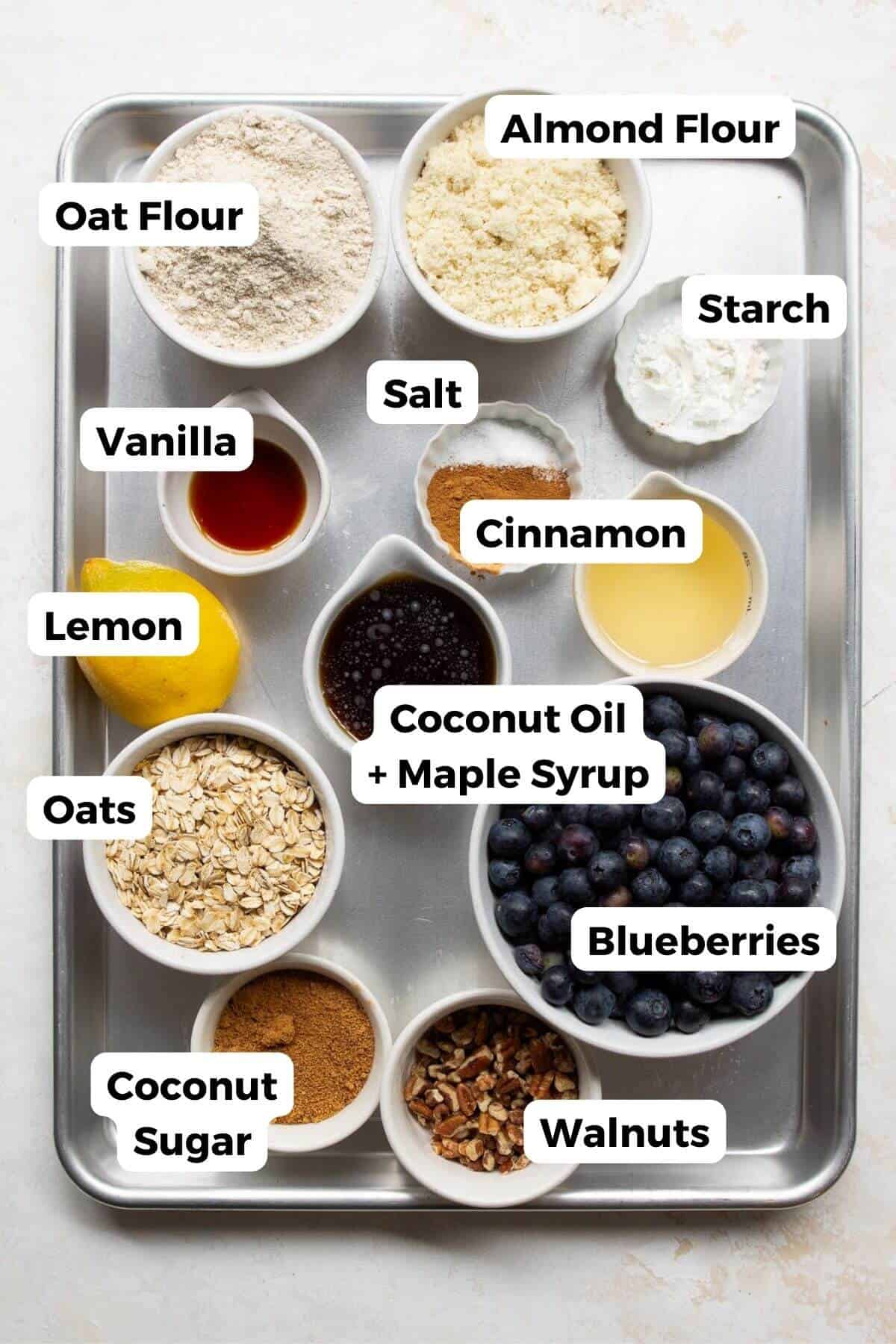 Ingredients for healthy blueberry crumble bars including blueberries, oat flour, almond flour, rolled oats, maple syrup, and lemon.