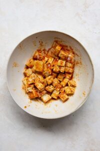 seasoned tofu cubes in a mixing bowl
