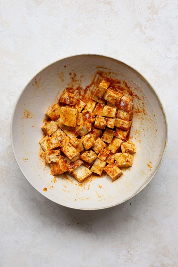 seasoned tofu cubes in a mixing bowl