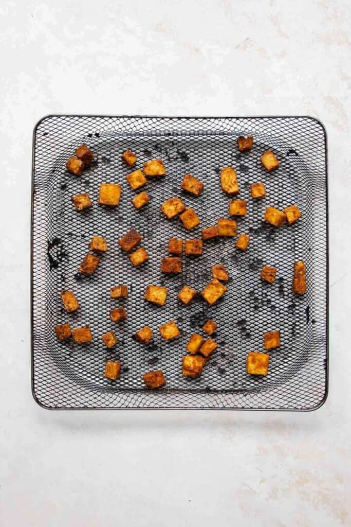 super crispy tofu cubes in an air fryer basket