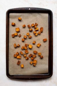 crispy tofu on a baking sheet after baking in oven