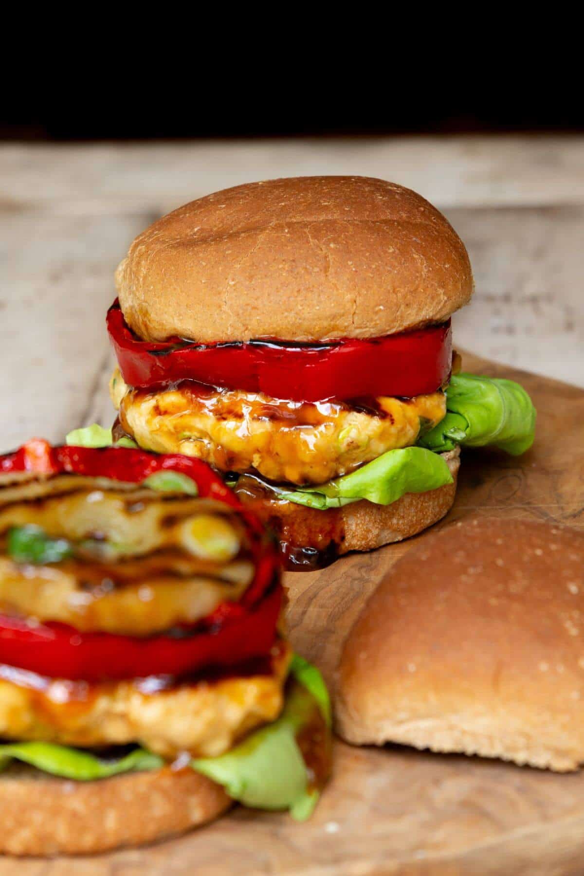 Juicy teriyaki chicken burgers with grilled pineapple and red bell pepper on toasted buns.