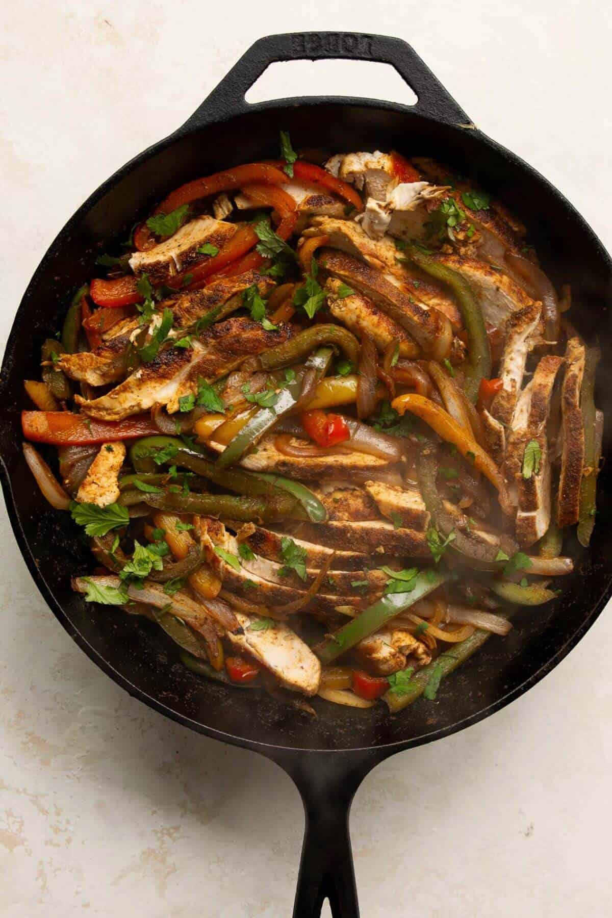 healthy chicken fajitas in a cast iron pan
