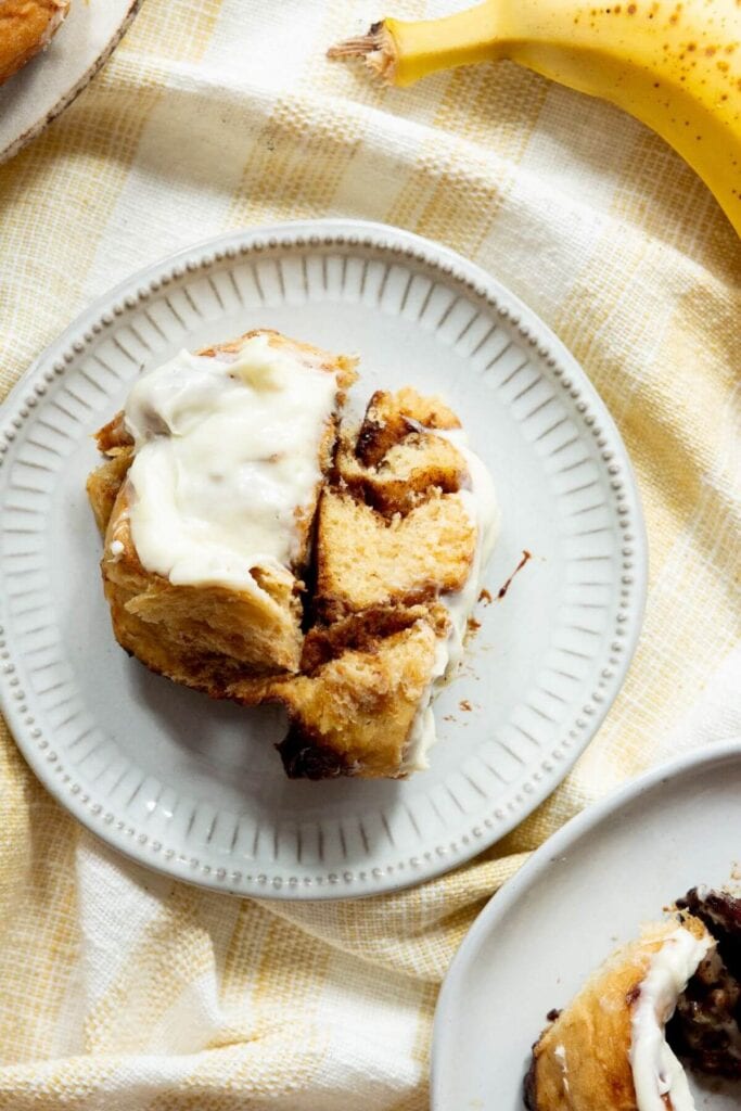 inside a soft and fluffy banana bread cinnamon roll with cream cheese icing