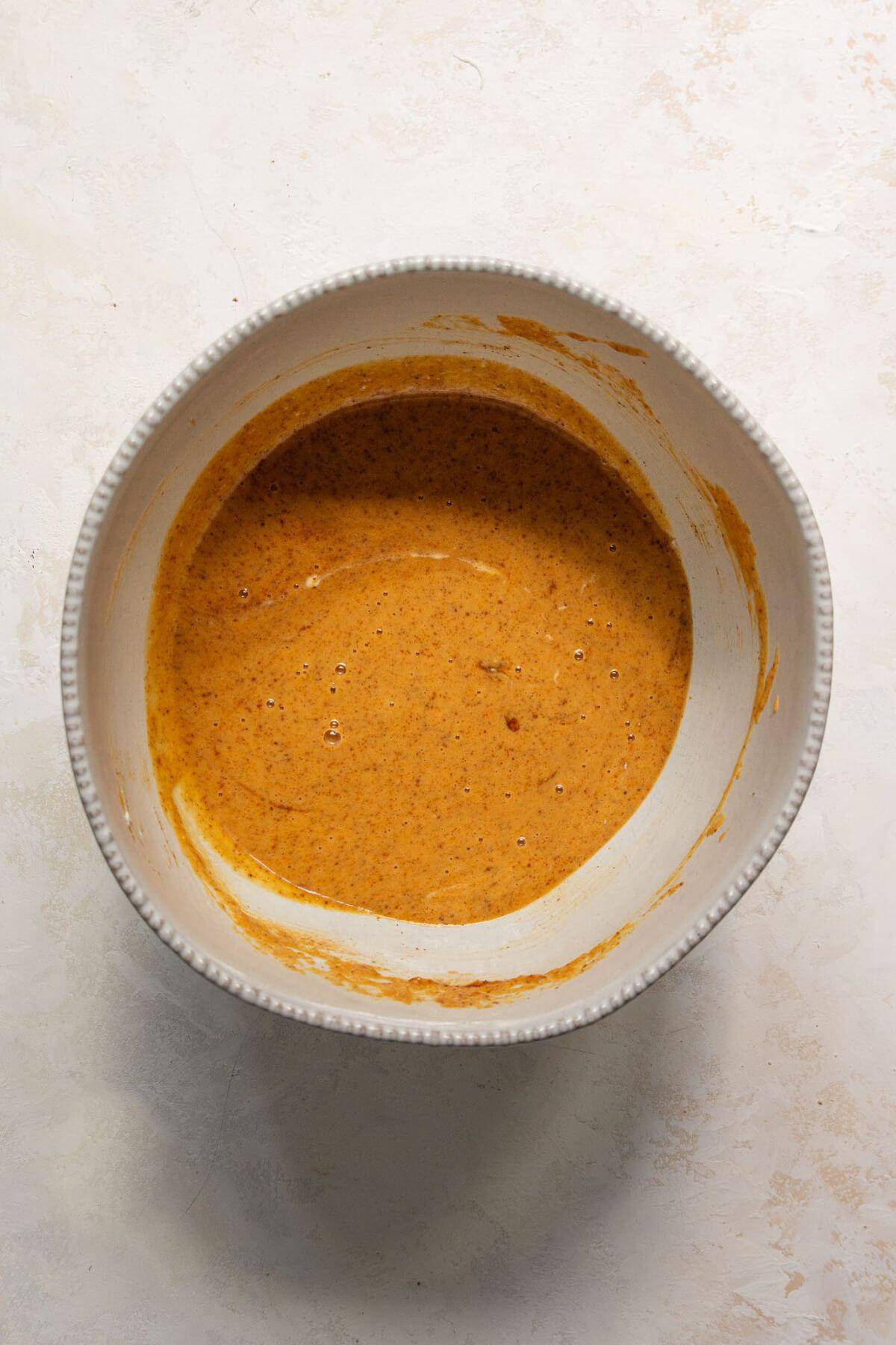 All the wet ingredients for pumpkin protein muffins whisked together in a large mixing bowl until smooth.