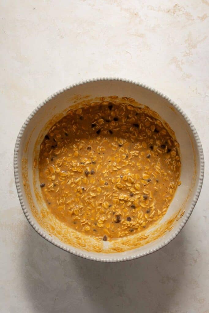 adding chocolate chips to pumpkin baked oatmeal batter