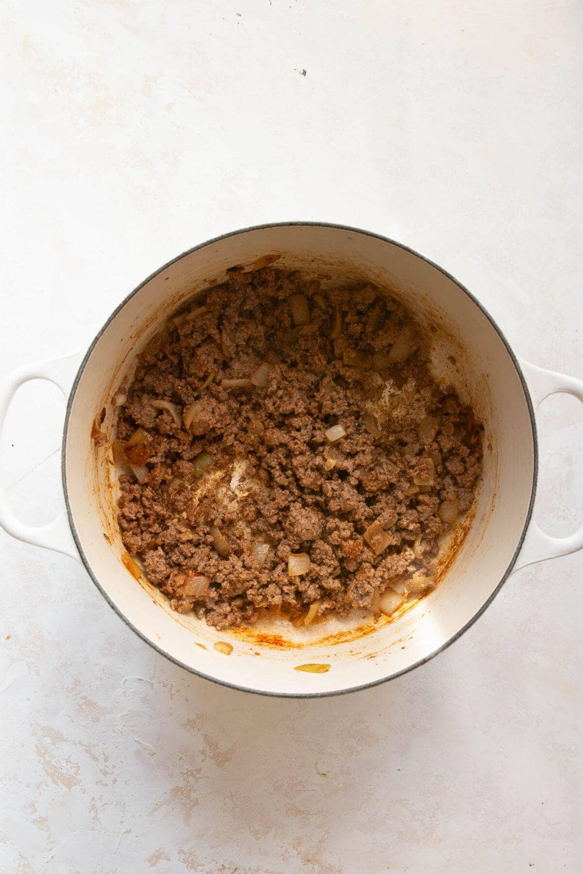 Browned ground beef with onions in a the pot.
