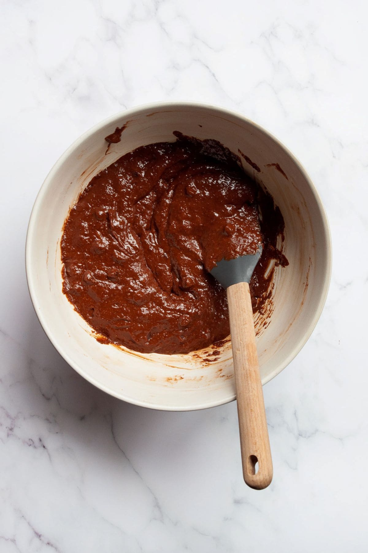Thick and fudgy flourless brownie batter in a mixing bowl.