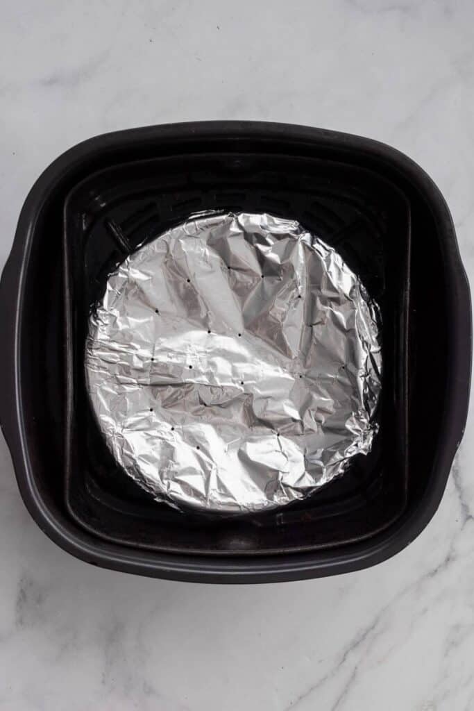 placing aluminum foil cover over air fryer frittata before cooking so it does not burn