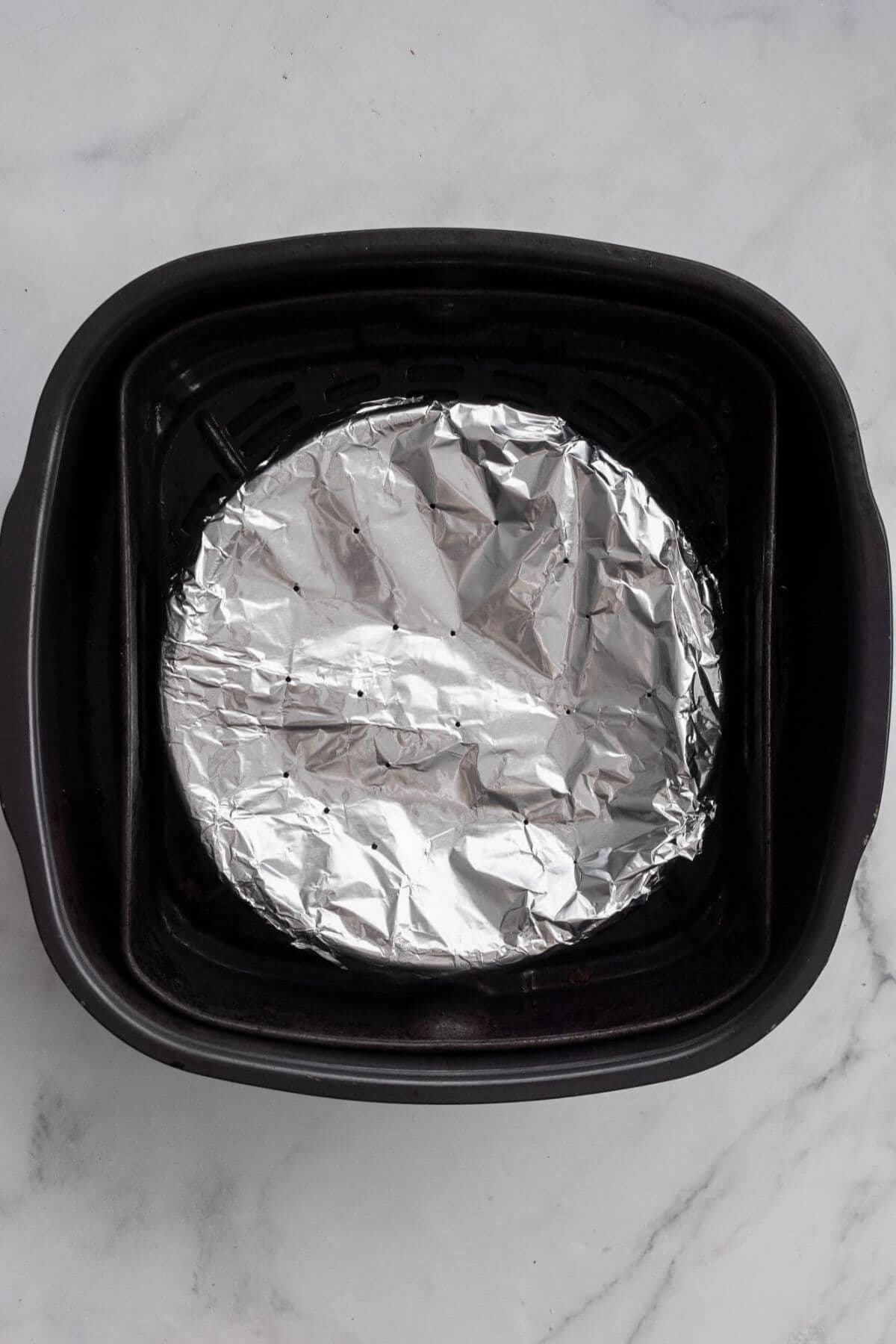 Frittata pan covered with foil inside the air fryer basket to prevent over-browning.