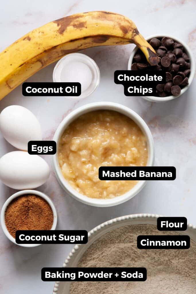 Ingredients in dairy free banana bread including: banana, flour, cinnamon, baking soda, baking powder, eggs, coconut oil, and chocolate chips