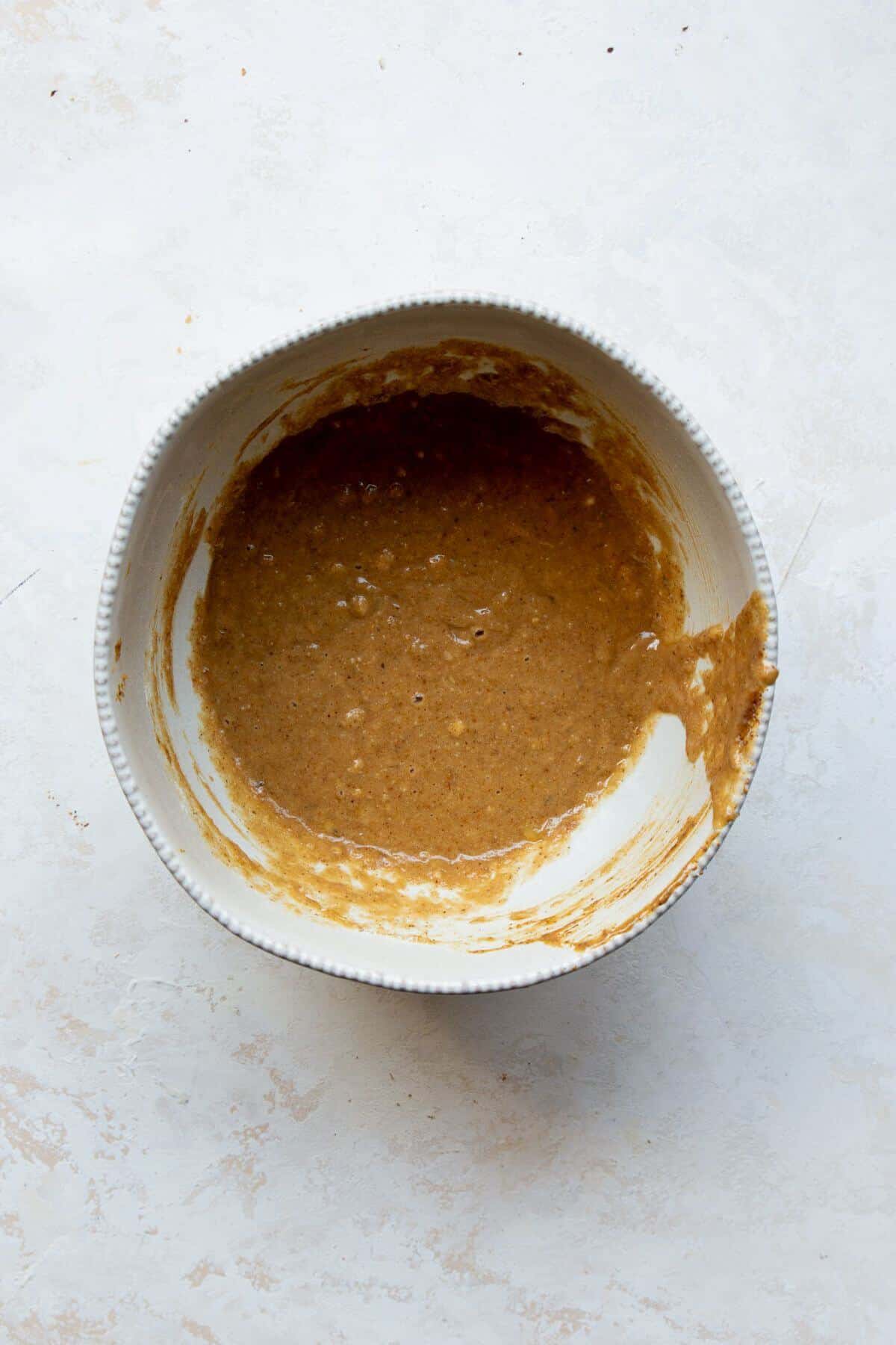 Almond flour banana donut batter mixed in a white bowl.