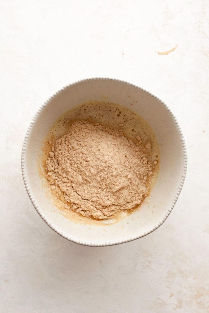 adding almond flour, cinnamon, oat flour, baking soda, and packing powder to the wet ingredients