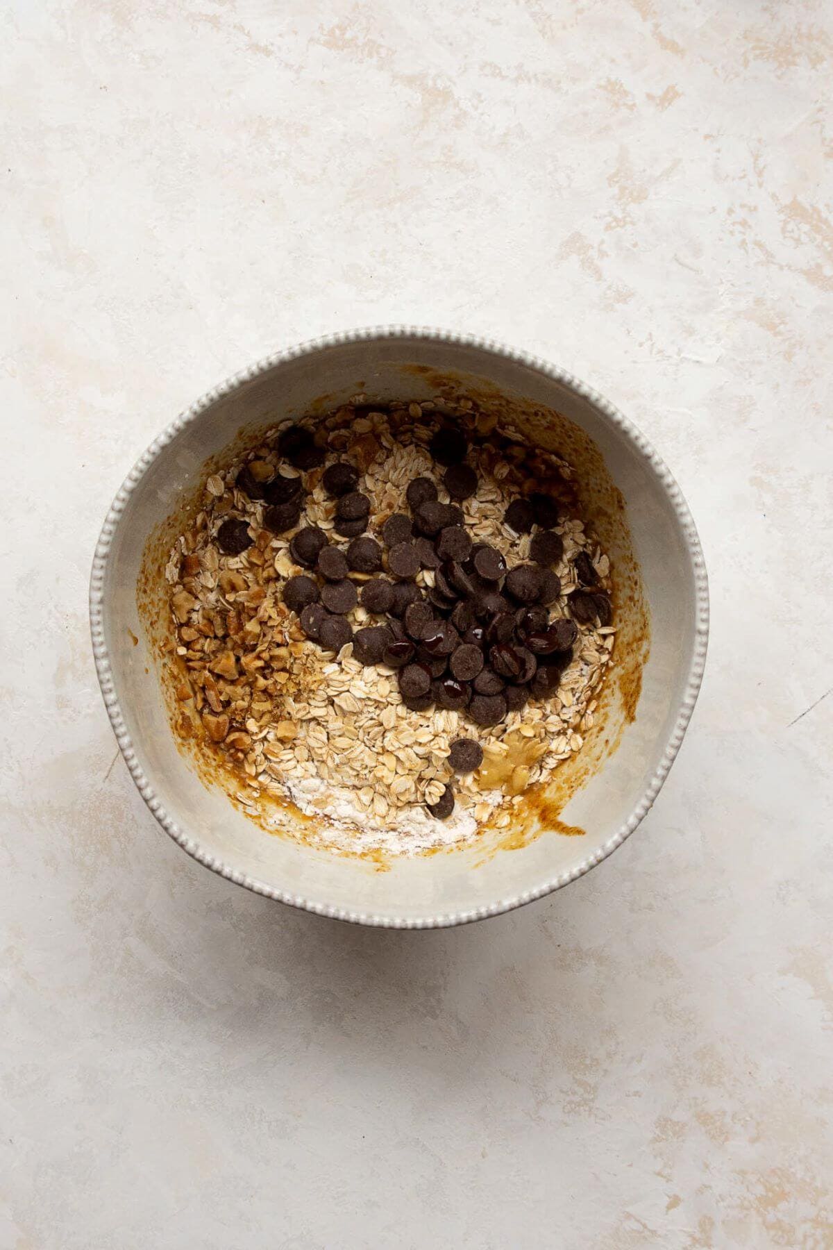 Oats, flour, walnuts, and chocolate chips added to cookie dough.