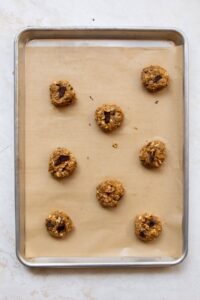 oatmeal walnut cookie dough balls on a baking sheet before baking