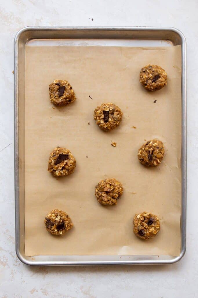 oatmeal walnut cookie dough balls on a baking sheet before baking