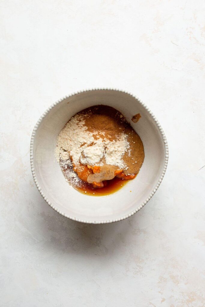 almond butter, coconut flour, vanilla extract, maple syrup, pumpkin puree, and pumpkin spice in a bowl to make the batter of the truffles
