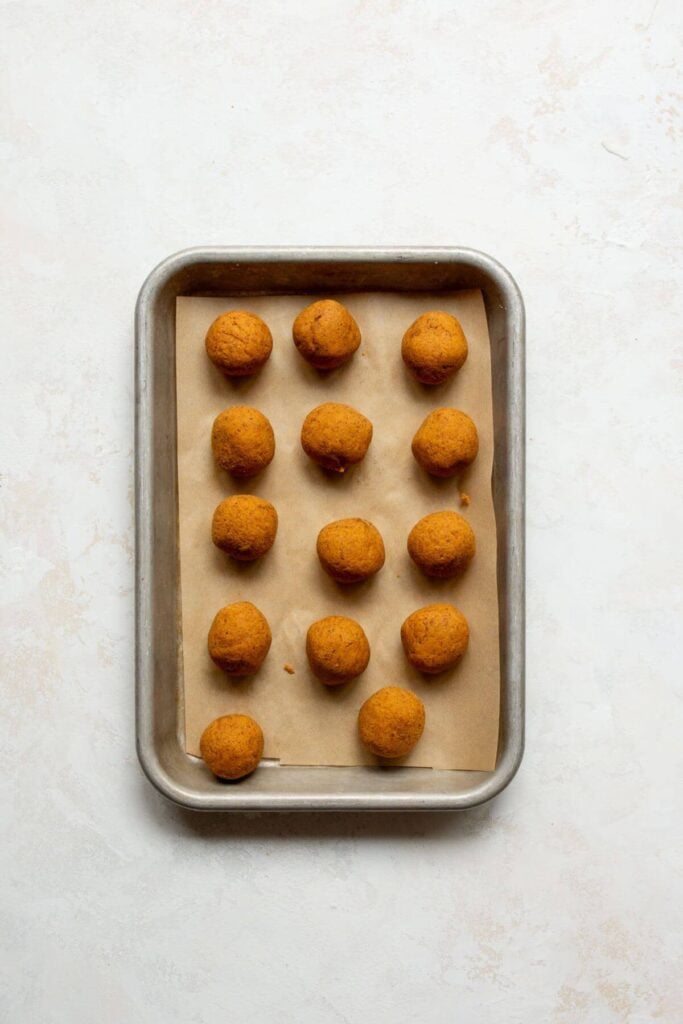 naked pumpkin spice truffles on a baking sheet before adding the melted chocolate shell